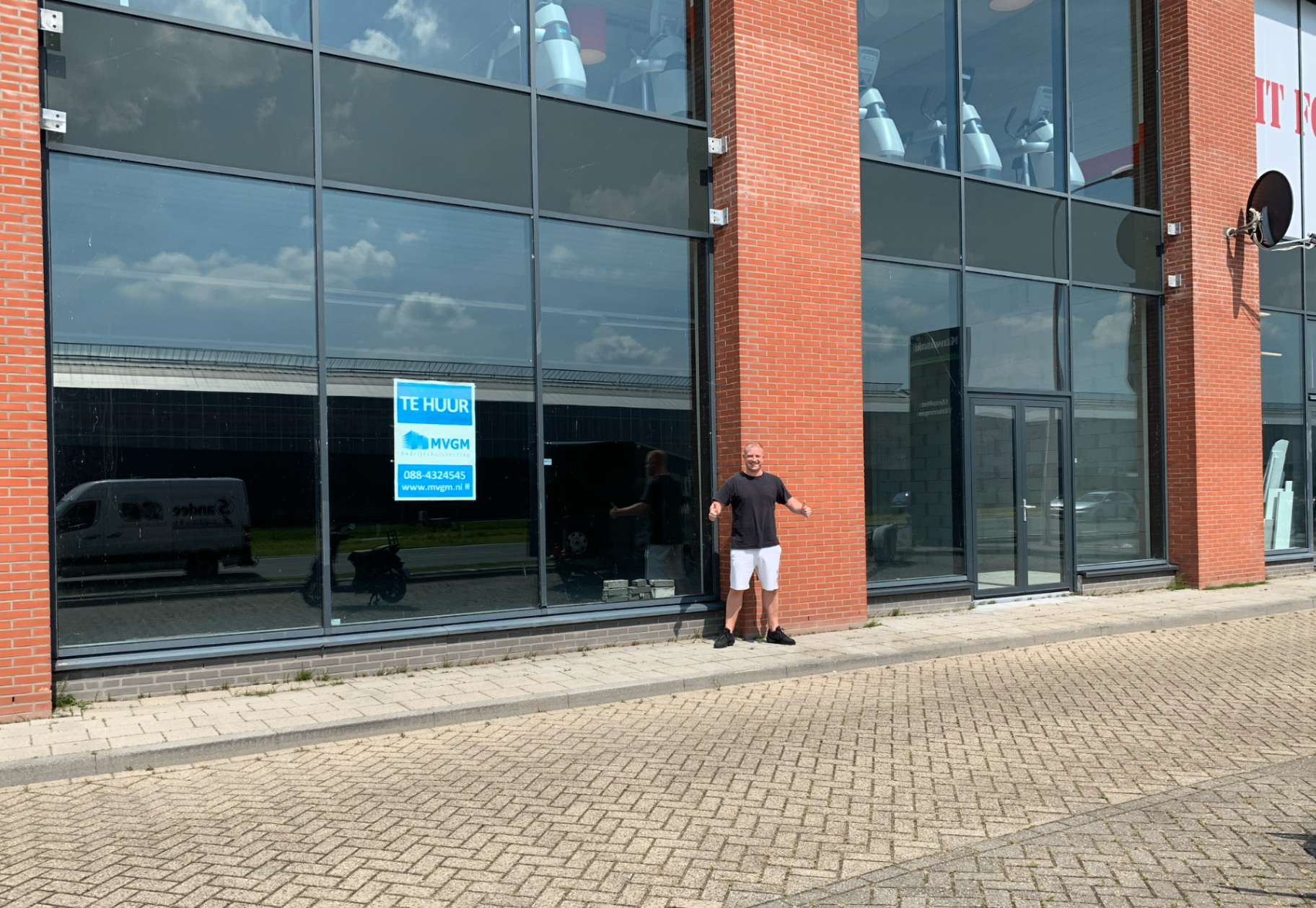 Jeroen met duimen omhoog voor het lege pand waar Stunna Car Lounge zou komen.