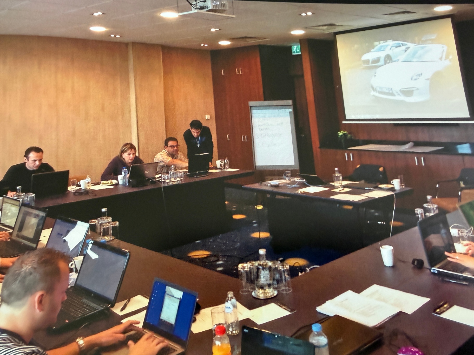 Mastermind-sessie met deelnemers achter laptops.